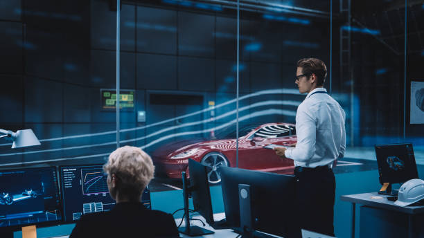 istock Engineering Research Agency Perform Aerodynamic Testing with a Modern Eco-Friendly Electric Sports Car in a Wind Tunnel. Professional Scientist Works on a Tablet Computer and Changes Testing Options. 1408906001