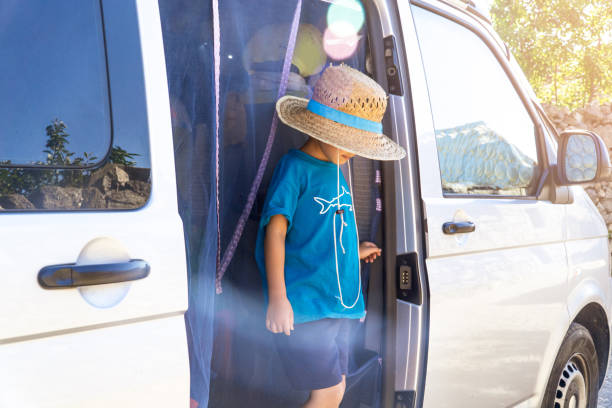 istock kid on a camper van door with straw hat 1408906465