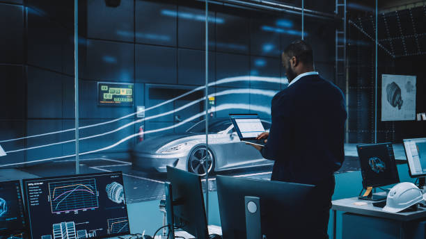 istock Engineering Research Agency Perform Aerodynamic Testing with a Modern Eco-Friendly Electric Sports Car in a Wind Tunnel. Professional Scientist Works on a Laptop Computer and Changes Testing Options. 1408906644