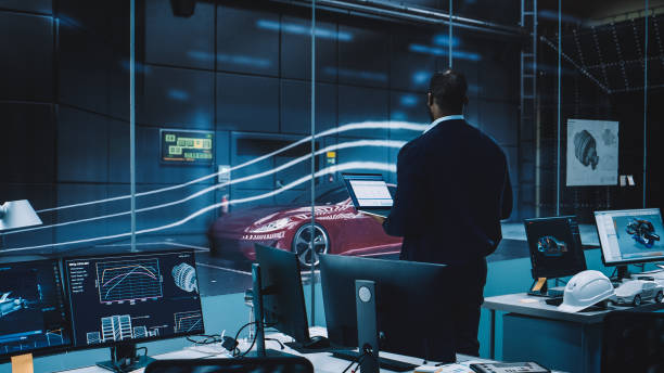 istock Engineering Research Agency Perform Aerodynamic Testing with a Modern Eco-Friendly Electric Sports Car in a Wind Tunnel. Professional Scientist Works on a Laptop Computer and Changes Testing Options. 1408906678