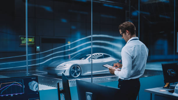 istock Engineering Research Agency Perform Aerodynamic Testing with a Modern Eco-Friendly Electric Sports Car in a Wind Tunnel. Professional Scientist Works on a Tablet Computer and Changes Testing Options. 1408906785