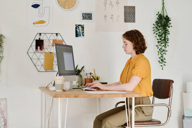 istock Young serious female freelancer or webdesigner concentrating on work 1408908728