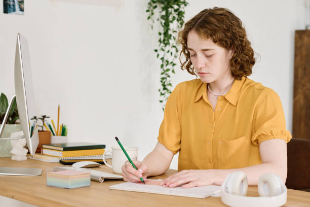istock Young creative female freelancer with ruler and pencil drawing sketch 1408908733