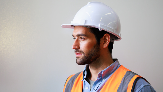 Portrait Professional mechanical engineering hispanic male in white safety hard hat helmet and look at camera at metal factory. Professional industrial warehouse