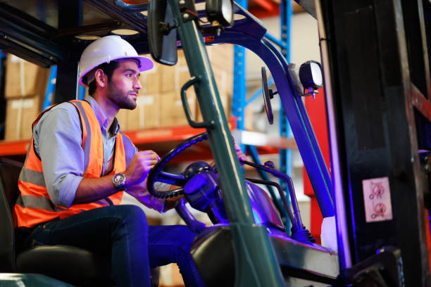 istock Warehouse staff driving forklift operator moving boxes in industrial container warehouse factory. Man worker woking with forklift. 1408913055