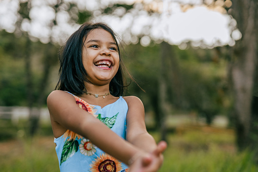 Female portrait of charming child of three years with a beautiful smile, cheerful shot on isolated pink.