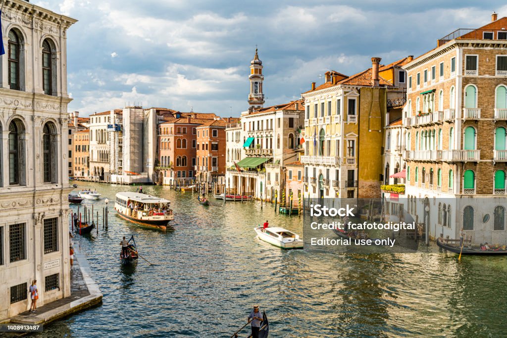 Gondolas and vaporetto in Canal Grande, Venice-Italy Venice - Italy July 5, 2022. View of Grand Canal in Venice, Italy with vaporetto and gondolas navigating on water. City Stock Photo