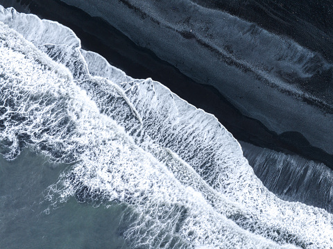 drone looking straight down for ocean waves on black sands beach abstract patterns in Iceland, Overhead Earth and Nature  Abstracts background concept