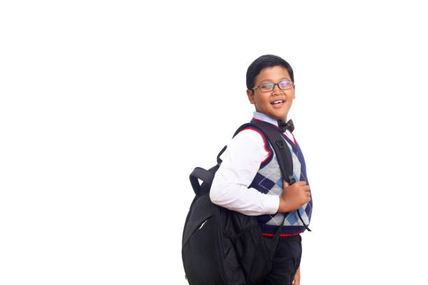 Handsome young asian schoolboy with backpack smiling over white background