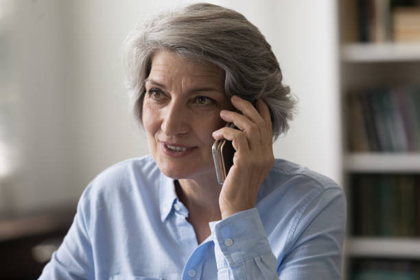istock Smiling satisfied elder grandma speaking on mobile phone 1408920922