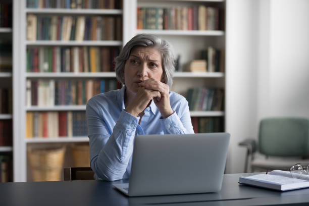 preocupado pensativo mulher de negócios maduro usando laptop - pensive women business mature adult - fotografias e filmes do acervo