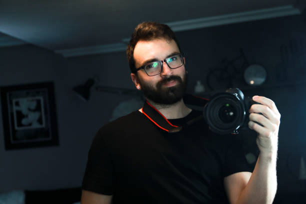 istock Handsome brown-haired guy with a beard, taking pictures of himself in a mirror because it is the photography day. 1408921417