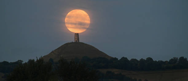 Glastonbury moon The full Supermoon appears to sit on top of Glastonbury Tor as it sets.
Glastonbury Tor is a hill near Glastonbury in the English county of Somerset. The Tor is mentioned in Celtic mythology, particularly in myths linked to King Arthur arthurian legend stock pictures, royalty-free photos & images
