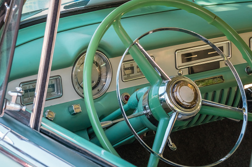 Close-up view of 1950s generic green classic car steering wheel.