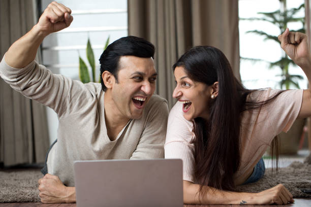 istock Ecstatic couple celebrating online success at home 1408924067