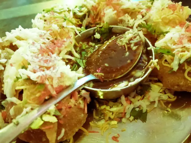 close up of Phuchka common street snack from Bangladesh. Panipuri or Golgappa. It's a round, hollow puri filled with a mixture of tamrind water and other chat items. Dahi or Doi phuchka.