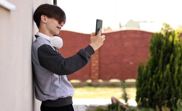istock Handsome Teen Using Smartphone outdoors. Attractive Young Man Communication Chatting on Social Networks Online. Student Listening Music on Cellphone. Concept People Leisure 1408926992