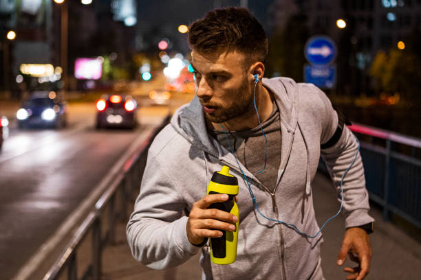 istock Young man running on a bridge at night 1408931310