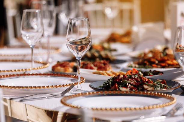 istock Empty glass set in restaurant. wedding, decor, celebration, holiday concept - romantic table setting with white tablecloth, plates, crystal glasses. 1408935882