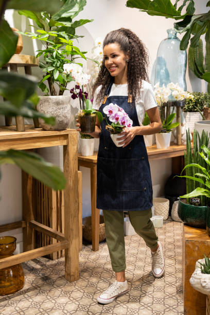 Full body shot of female African-American small business owner in her flower `shop stock photo