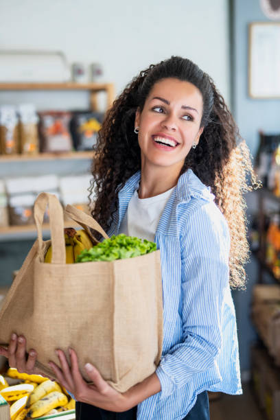 그녀의 유기농 식료품 점에서 일하는 동안 웃고있는 젊은 여성 아프리카 계 미국인 성공적인 기업가의 중간 장면 - 2503 뉴스 사진 이미지
