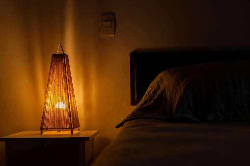 Bedroom lamp lit on the bedside table. bedroom concept. Hostel concept. copy space