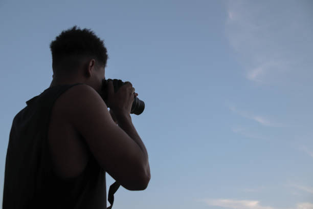 istock Young man taking pictures with camera 1408940325