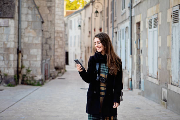 istock Young woman is texting in an old town 1408942535