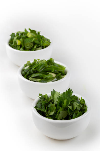 Sliced cilantro, chives and parsley in ramekin.