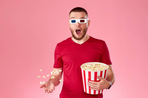 istock young man in 3d glasses throwing up and eating popcorn 1408953973