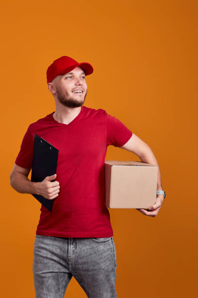 istock Delivery man holding clipboard and empty cardboard box i 1408954079