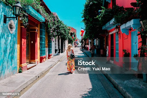 istock Young woman walking on a street of historical city of Cartagena, Colombia 1408955173