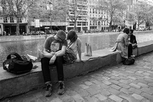 05-16-2016 Paris, France. Paris, France. Young people lie and sit next to the water of the Canal Saint-Martin  -  May:people relaxing outdoor !