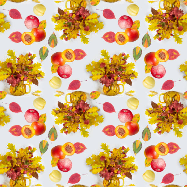 Seamless pattern with bouquets of autumn leaves and fruits on a white background. The concept of the seasons stock photo