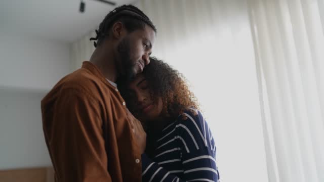 Young couple embracing each other giving emotional support at home