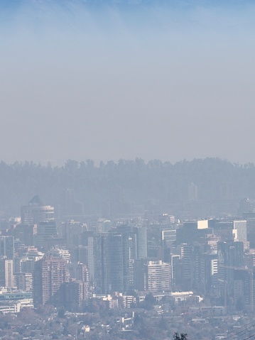 Santiago de Chile seen from the surrounding Andes mountains on a midwinter day, when the winter temperature inversion causes pollution to hang over the capital city for months at a time