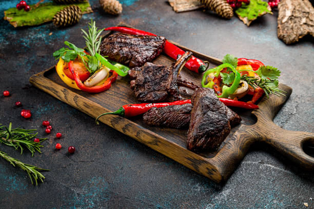 istock Venison steak with lingonberry sauce and different meat on the board 1408963969