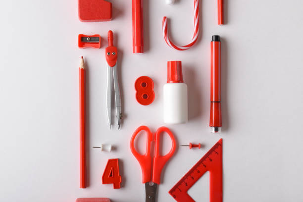 Various stationery in red in the center on a white background. Back to school. A banner with office elements with space for text. Space for copying. Flat position, top view.