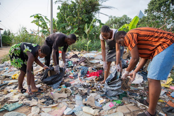quatre jeunes adultes ramassent des ordures dans une décharge illégale en plein air en afrique, des gens contre la pollution - bag garbage bag plastic black photos et images de collection
