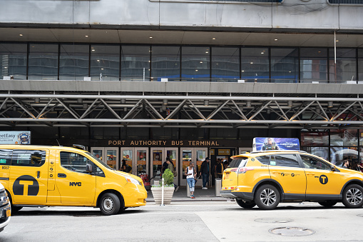 New York, NY, USA - June 2, 2022: Taxis parked outside an entrance to the Port Authority Bus Terminal.