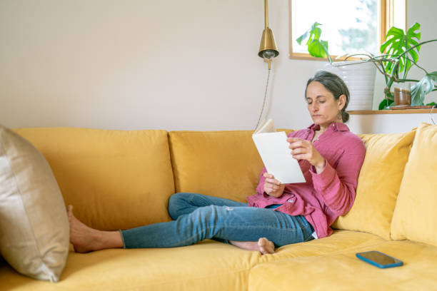istock Woman relaxing at home with a good book 1408973409