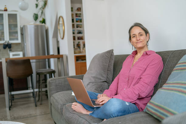 istock Contemplative woman using laptop computer at home 1408973431