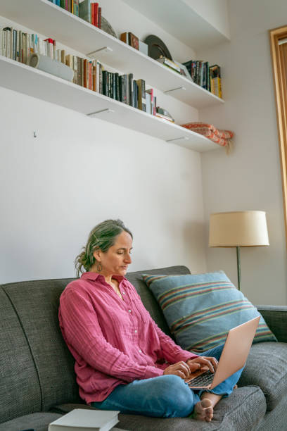 istock Woman relaxing at home and using laptop computer 1408973438