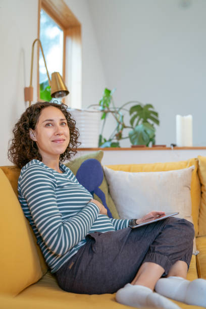istock Pregnant woman relaxing at home using tablet computer 1408973448