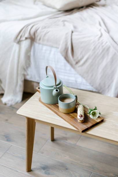 istock Coffee in cup, ceramic teapot, sweet eclair on serving tray 1408980864