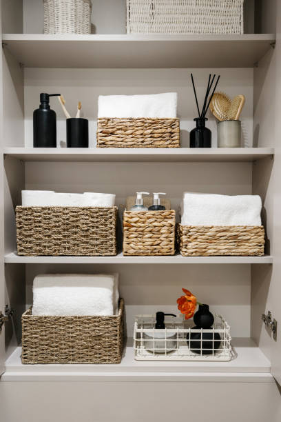 lemari kamar mandi dengan gulungan kertas toilet, handuk mandi putih dan botol kosmetik - storage bathroom potret stok, foto, & gambar bebas royalti