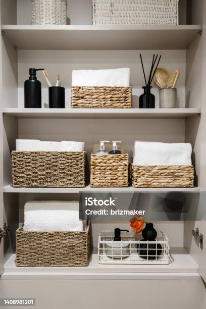 Bathroom Cabinet With Toilet Paper Rolls White Bath Towels And Cosmetics Bottles Stock Photo - Download Image Now