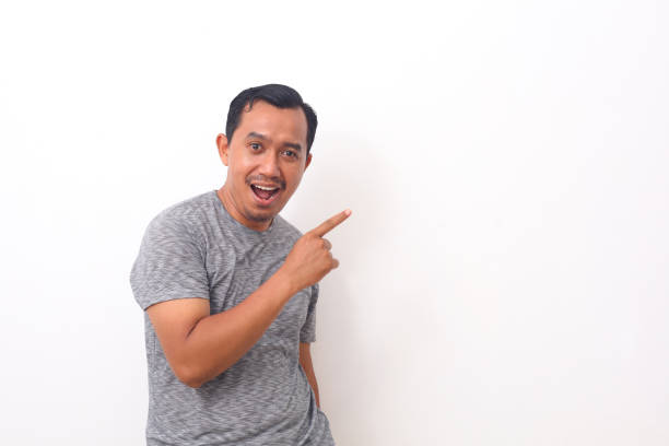 istock Portrait of asian man pointing something on empty space. Isolated on white with copyspace 1408999092