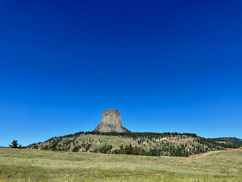Devils Tower, Wyoming, USA - July 8, 2022: The iconic “Devils Tower” rises over the plains in the Black Hills of northwest Wyoming on a hot summer day.