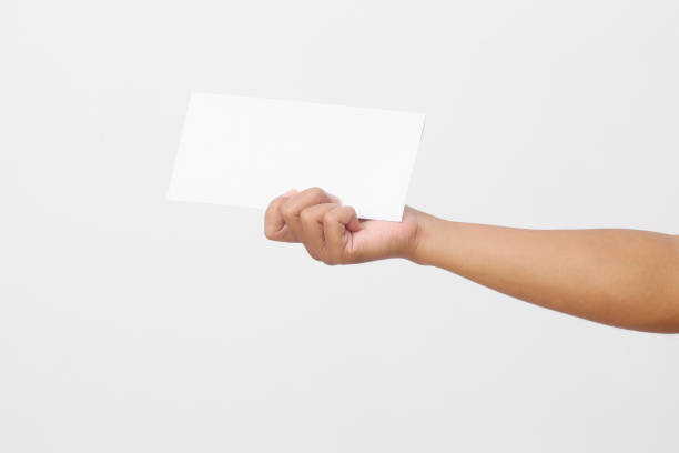 istock Man's hand holding envelope isolated on white background. Close up 1409008138